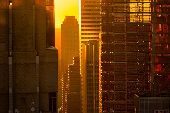 The sun shines through Manhattan buildings